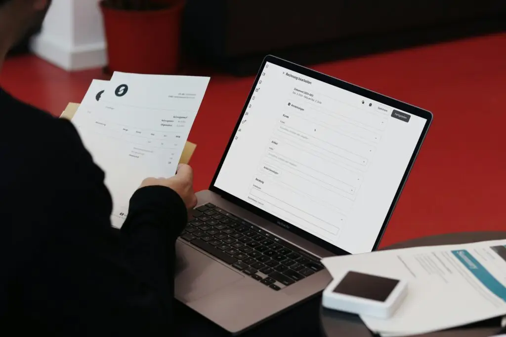 laptop and invoices - money saving tips for small businesses